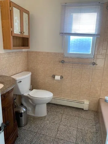 a bathroom with a toilet a sink and a window