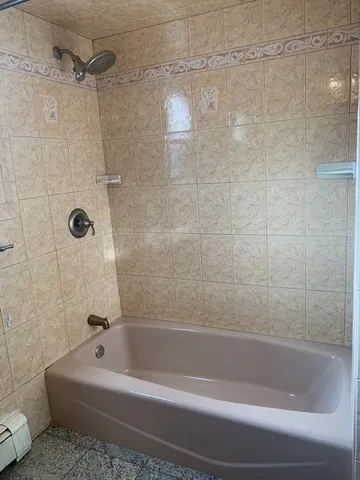 a white bath tub sitting next to a white sink and vanity