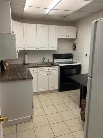a kitchen with granite countertop white cabinets and stainless steel appliances