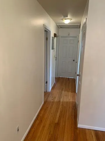 a view of a hallway with wooden floor