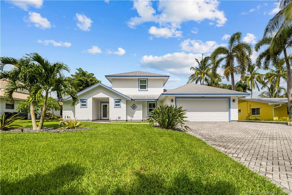 1359 Southwest Dyer Point Road Palm City, FL 34990 - Photo 54 of 55 a front view of a house with a yard and garage