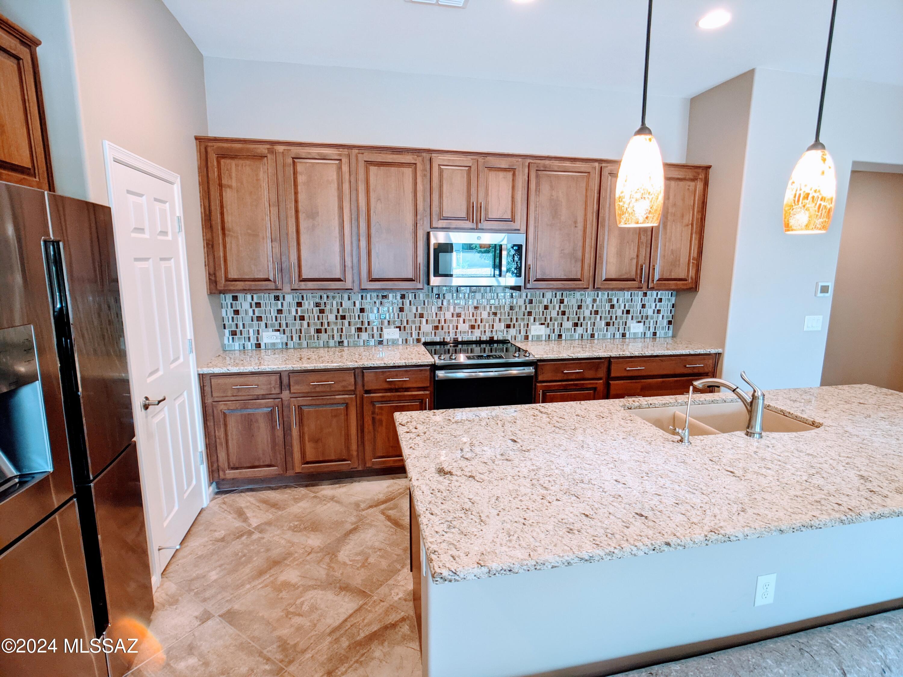 61021 East Slate Road Oracle, AZ 85623 - Photo 1 of 18 a kitchen with stainless steel appliances kitchen island granite countertop wooden cabinets and a granite counter tops