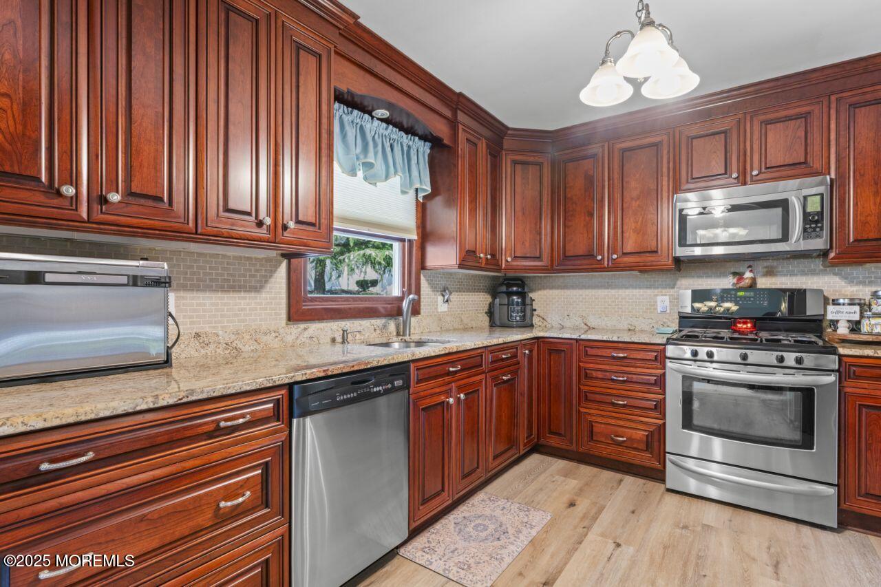 31 Cedar Avenue South Amboy, NJ 08879 - Photo 7 of 41 a kitchen with stainless steel appliances granite countertop wooden cabinets a stove a sink and dishwasher