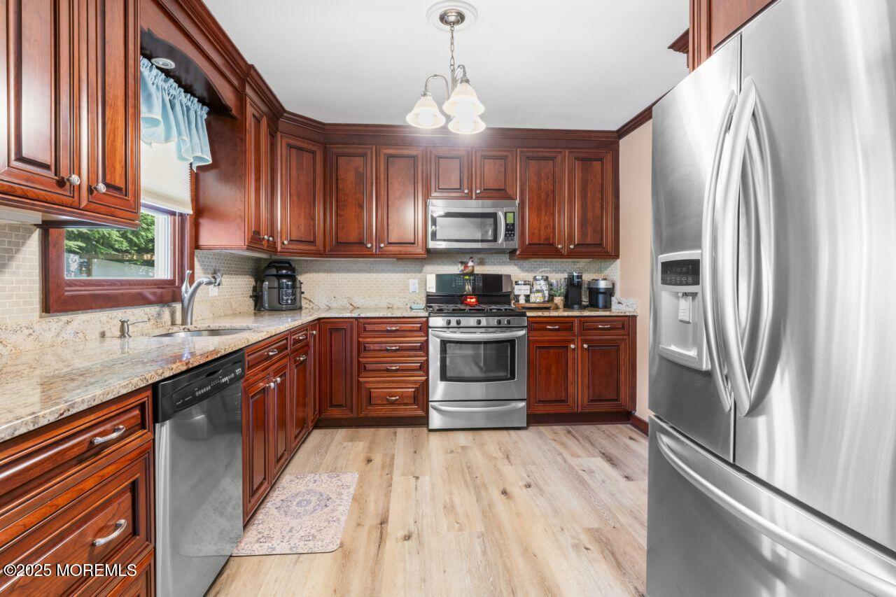 31 Cedar Avenue South Amboy, NJ 08879 - Photo 9 of 41 a kitchen with stainless steel appliances granite countertop a stove top oven a refrigerator a sink and dishwasher with wooden floor