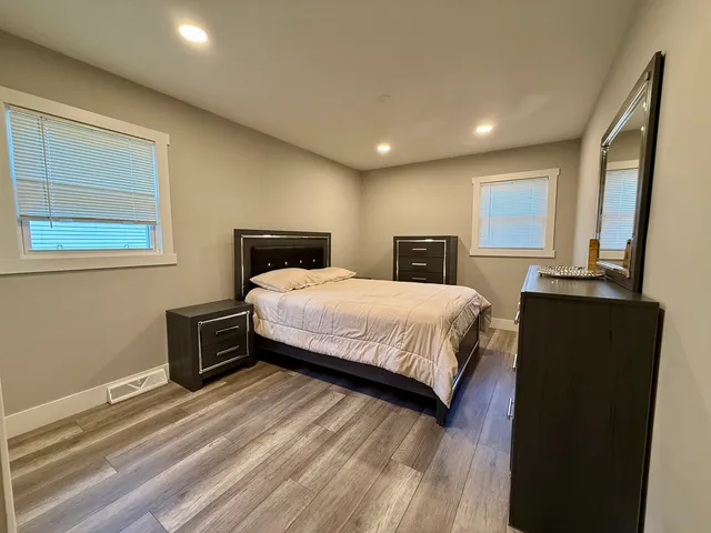 a bedroom with a bed and wooden floor