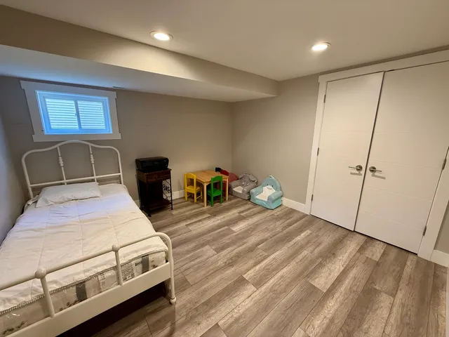 a bedroom with a bed and a potted plant on dresser