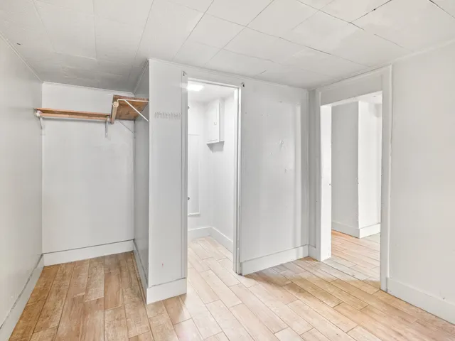 a view of a hallway with wooden floor and entryway