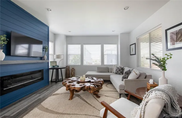 a living room with furniture a flat screen tv and kitchen view