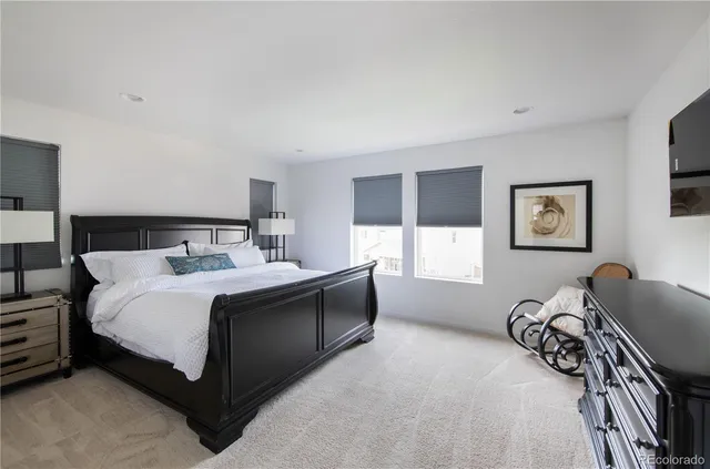 a bed sitting in a bedroom next to a lamp next to a window