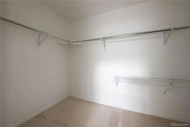 a bedroom with a bed a chair and next to a window