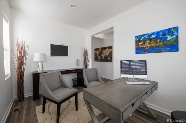 a kitchen with stainless steel appliances a sink a stove a refrigerator cabinets and a dining table