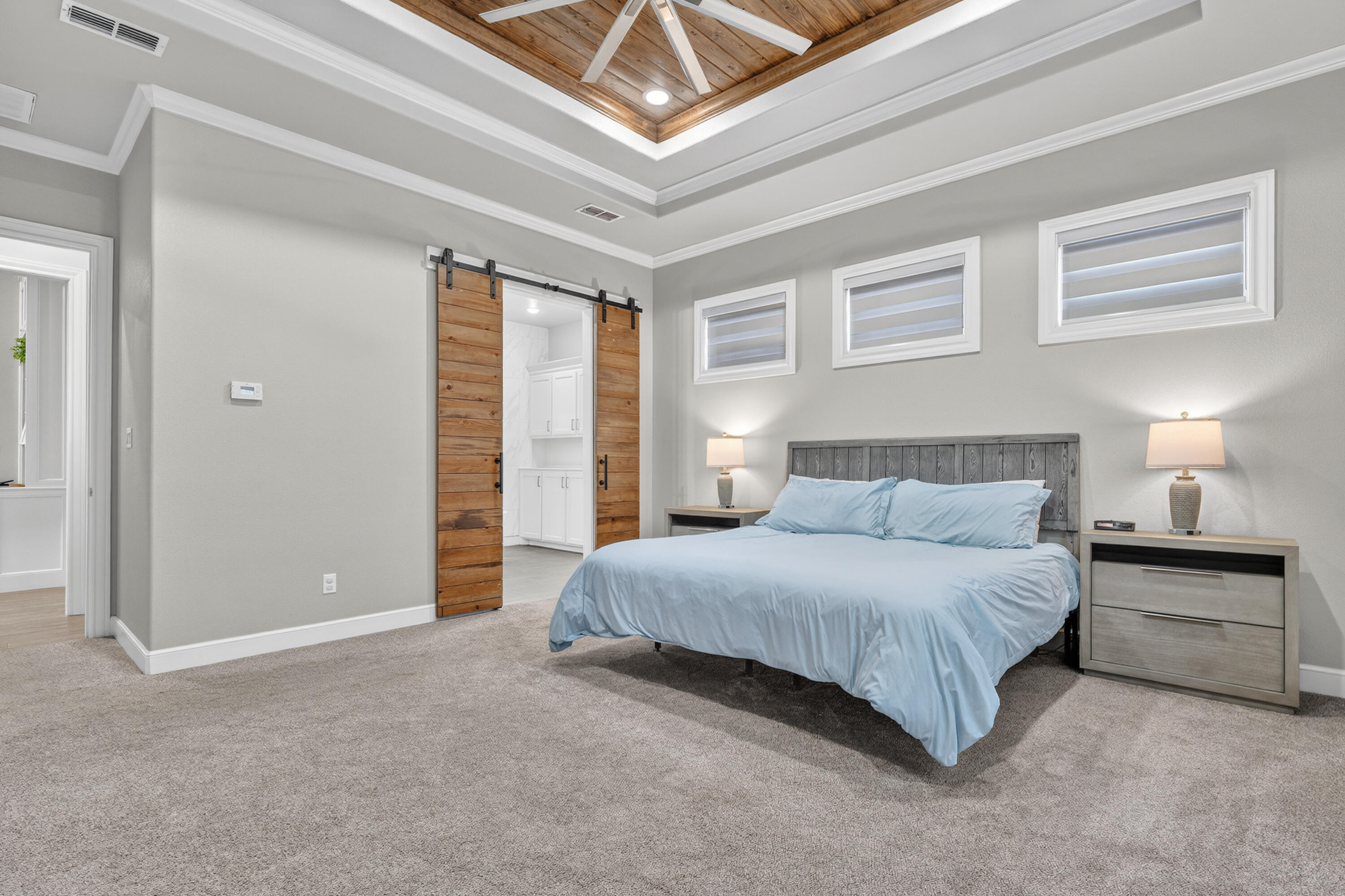4003 140th Street Lubbock, TX 79423 - Photo 18 of 50 a spacious bedroom with a bed a table and painting