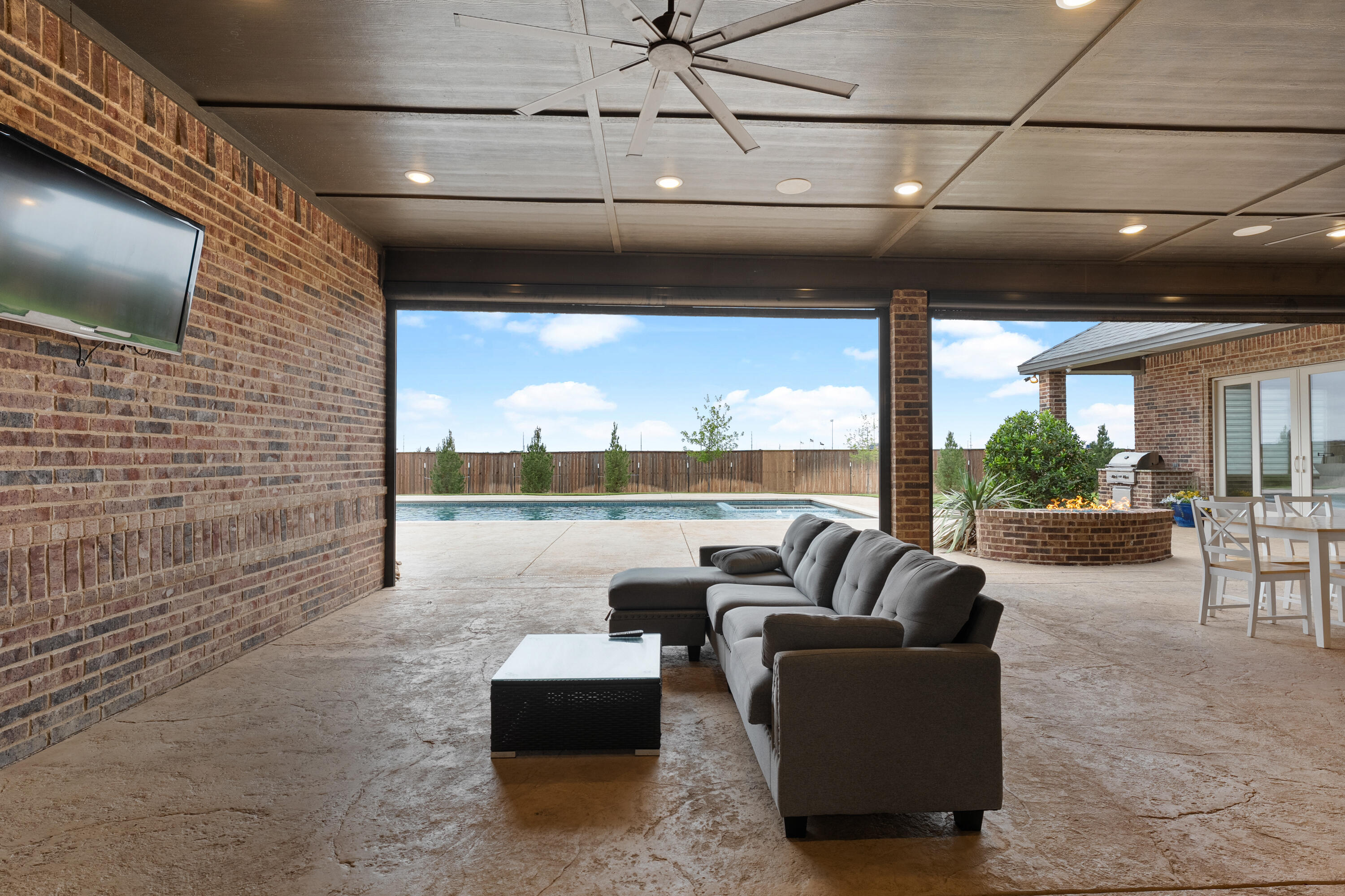 4003 140th Street Lubbock, TX 79423 - Photo 38 of 50 a living room with patio fireplace furniture and a flat screen tv