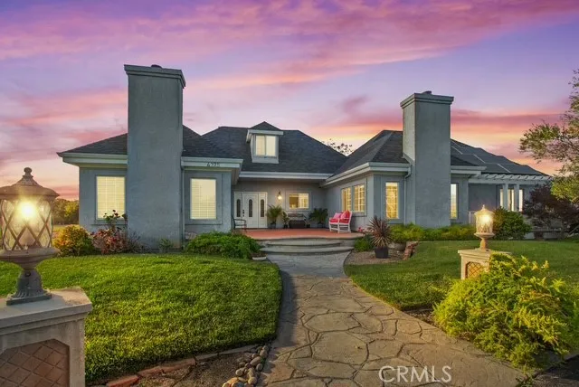 a front view of a house with a yard and potted plants