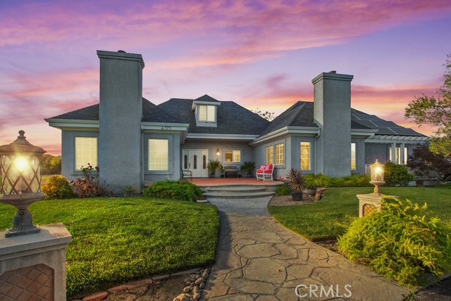 a front view of a house with a yard and potted plants