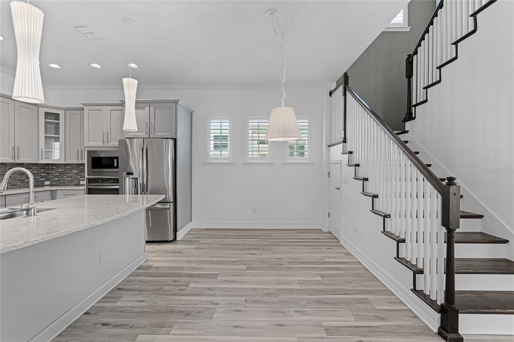 1515 Resolute Street Celebration, FL 34747 - Photo 18 of 56 a view of a kitchen with white cabinets and stainless steel appliances