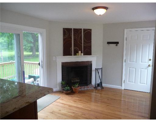 67 Maple Street Coventry, RI 02816 - Photo 7 of 12 Living Room. Living room with fireplace, sliders to rear deck overlooking beautiful 1 acre property.