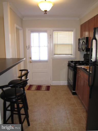 5152 Stafford Road Baltimore, MD 21229 - Photo 6 of 22 a kitchen with a sink a window and cabinets