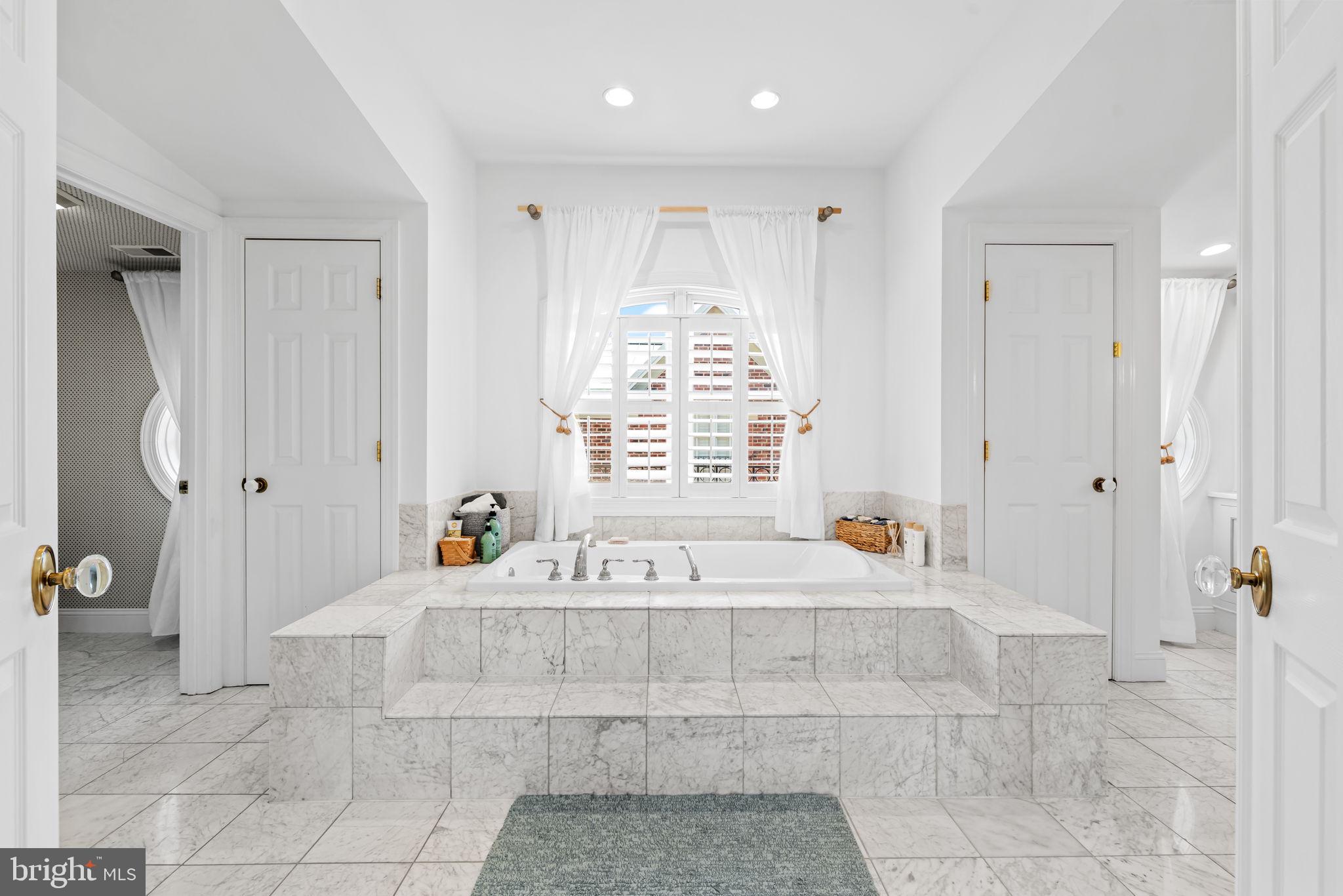2331 Boston Street, Unit 1 Baltimore, MD 21224 - Photo 55 of 74 a spacious bathroom with a tub shower and mirror