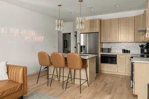 a kitchen with stainless steel appliances granite countertop a refrigerator a stove a sink dishwasher with a dining table and chairs