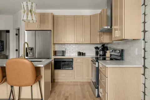 a kitchen with stainless steel appliances granite countertop a sink refrigerator and cabinets