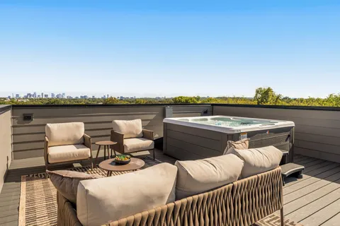 a roof deck with couches and wooden floor