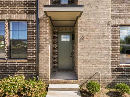 a view of a brick house with potted plants