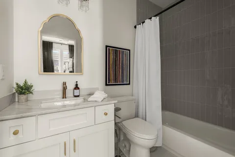 a bathroom with a granite countertop sink toilet and shower