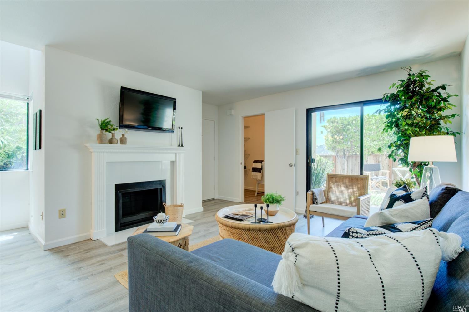 100 Marin Center Drive, Unit 32 San Rafael, CA 94903 - Photo 1 of 1 a living room with furniture a fireplace and a flat screen tv