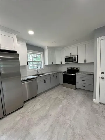 a large kitchen with cabinets and stainless steel appliances