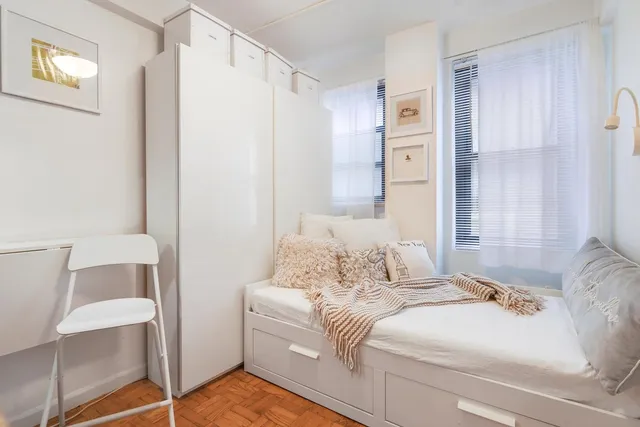 a bedroom with a bed and a table chair