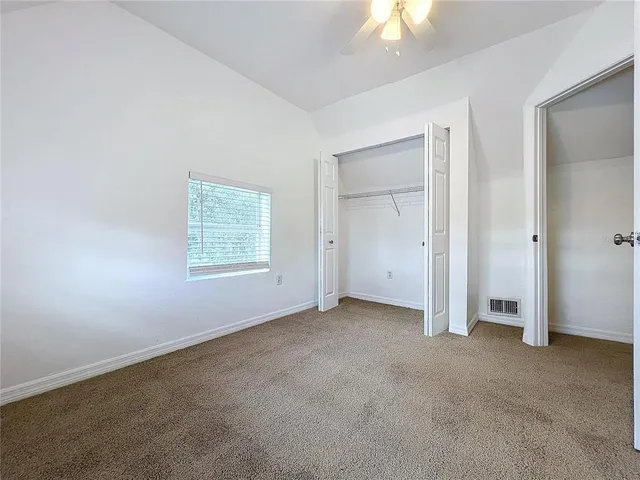 an empty room with a window and a fan