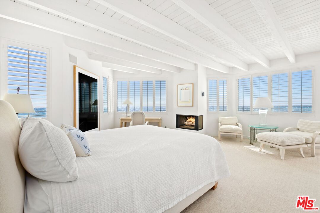 24254 Malibu Road Malibu, CA 90265 - Photo 9 of 26 a large bed sitting in a spacious bedroom next to a window and a chair