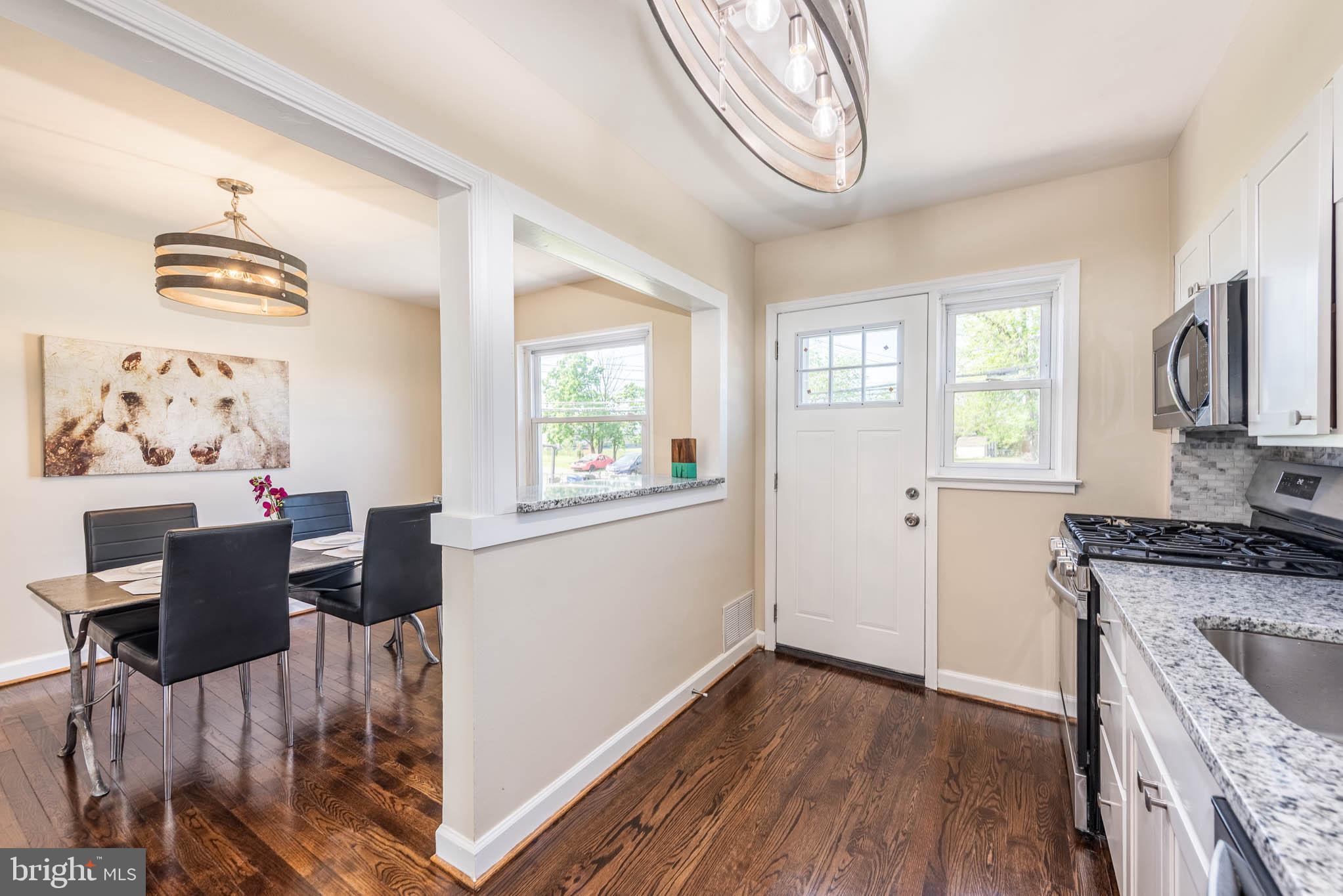 3300 Wallford Drive Baltimore, MD 21222 - Photo 11 of 31 a kitchen with stainless steel appliances granite countertop a stove top oven a sink dishwasher and white cabinets with wooden floor