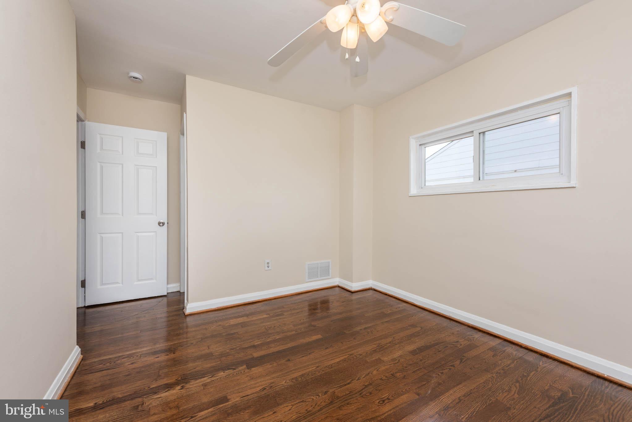 3300 Wallford Drive Baltimore, MD 21222 - Photo 15 of 31 an empty room with wooden floor and windows