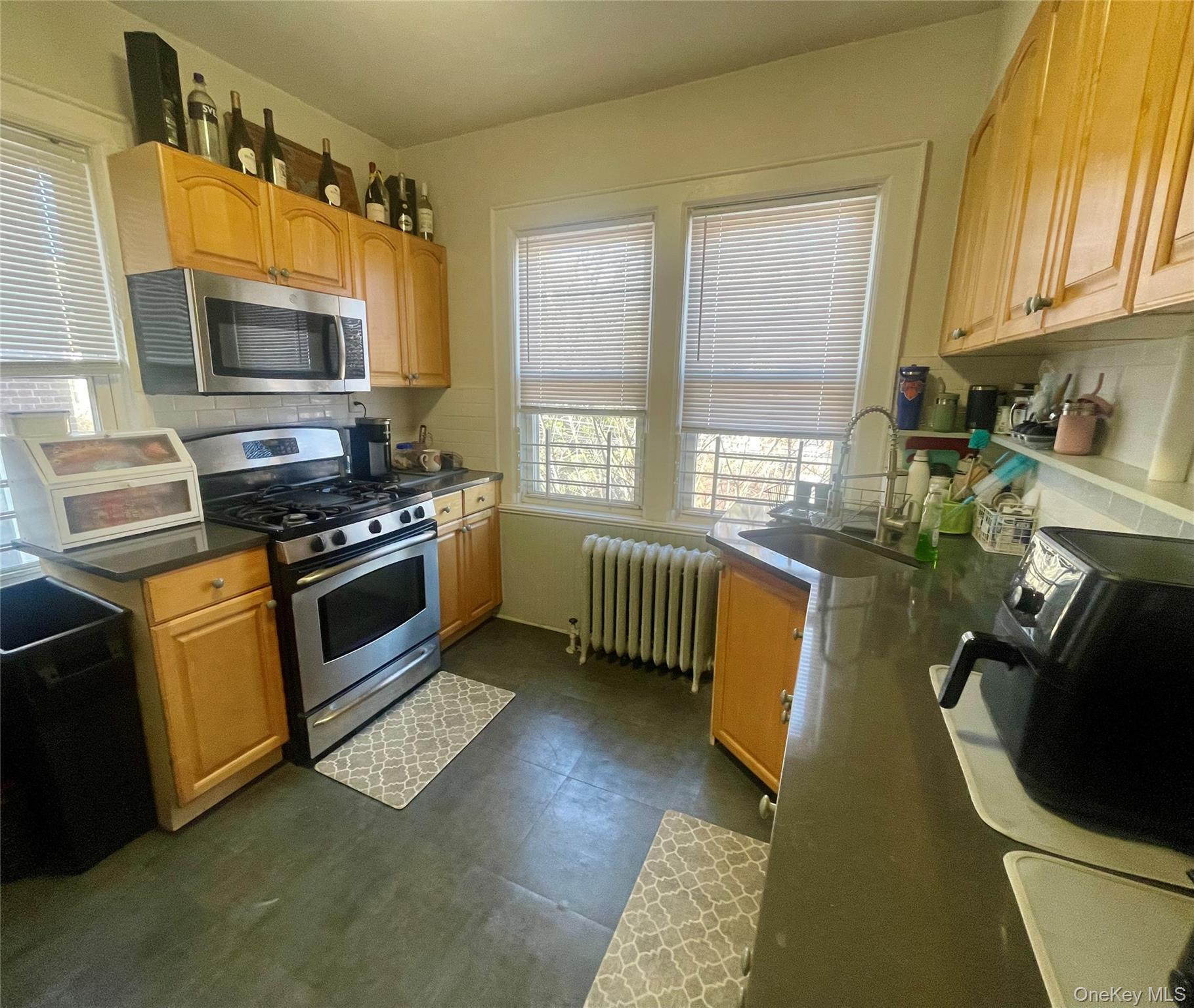 372 East 235th Street Bronx, NY 10470 - Photo 15 of 36 a kitchen with stainless steel appliances granite countertop a stove a sink and a microwave