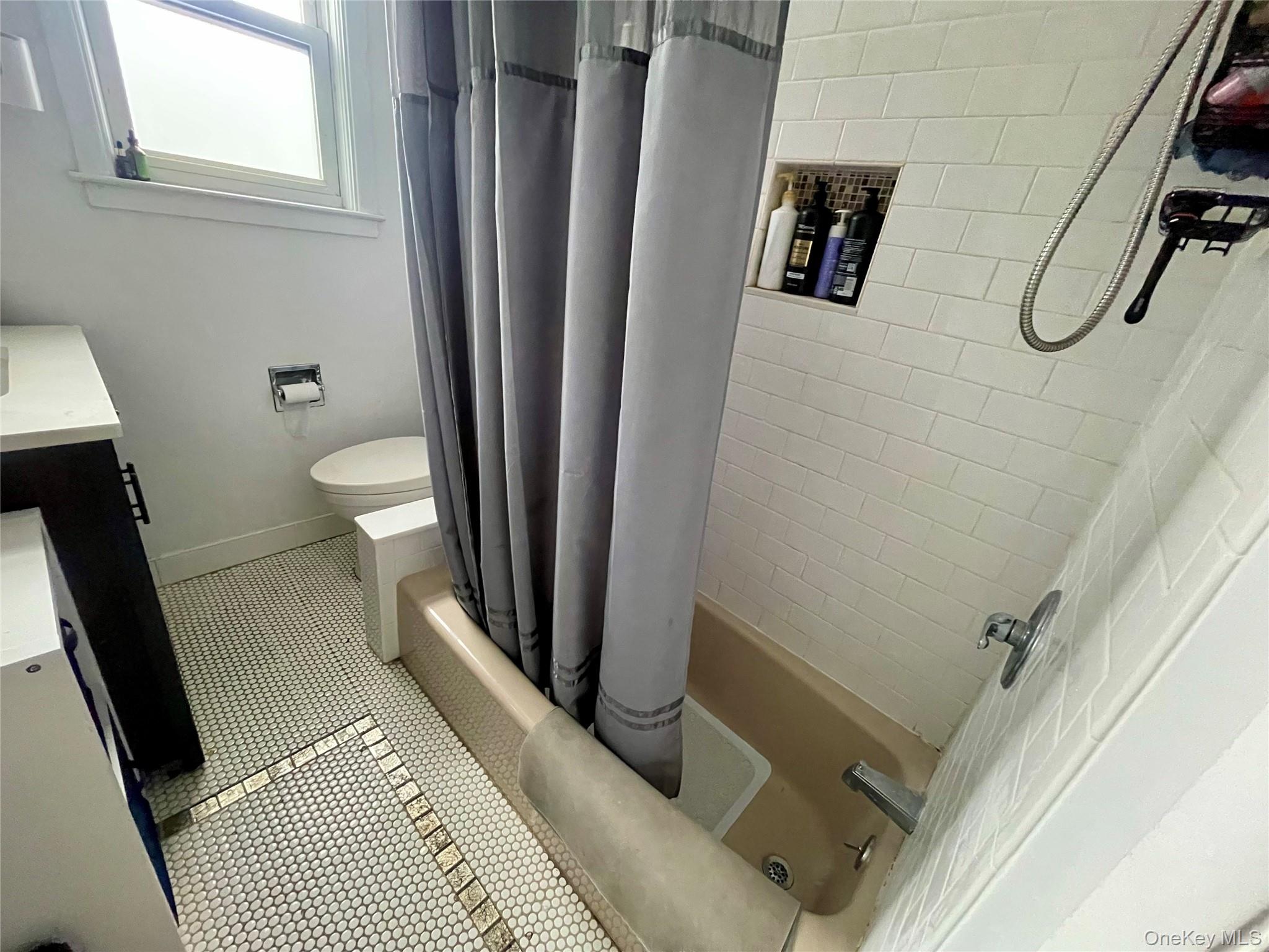 372 East 235th Street Bronx, NY 10470 - Photo 22 of 36 a bathroom with a sink a toilet a shower a vanity and a window
