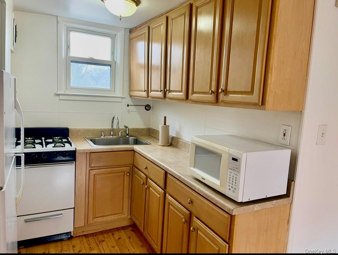 372 East 235th Street Bronx, NY 10470 - Photo 24 of 36 a kitchen with stainless steel appliances white cabinets and a sink