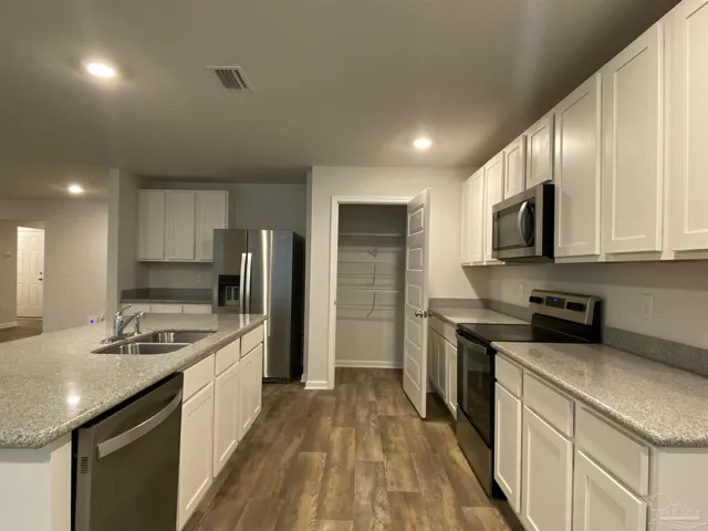 a kitchen with stainless steel appliances granite countertop a sink stove microwave and refrigerator