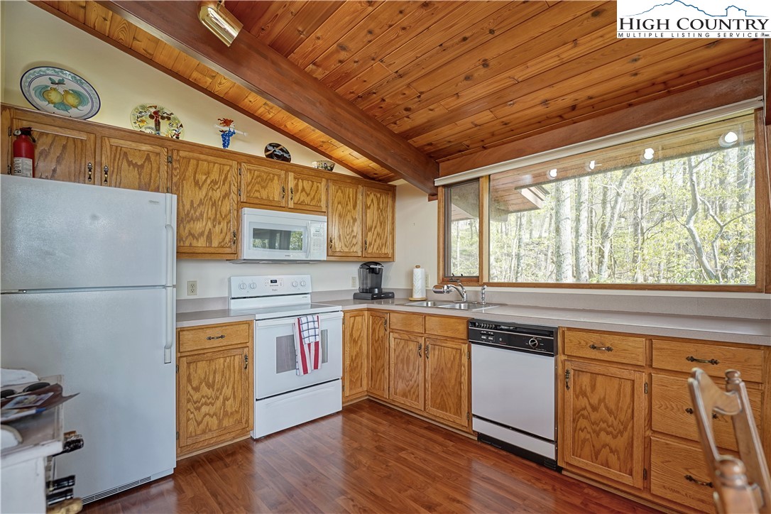 407 Pine Ridge Road Beech Mountain, NC 28604 - Photo 11 of 31 a kitchen with wooden floors and white stainless steel appliances