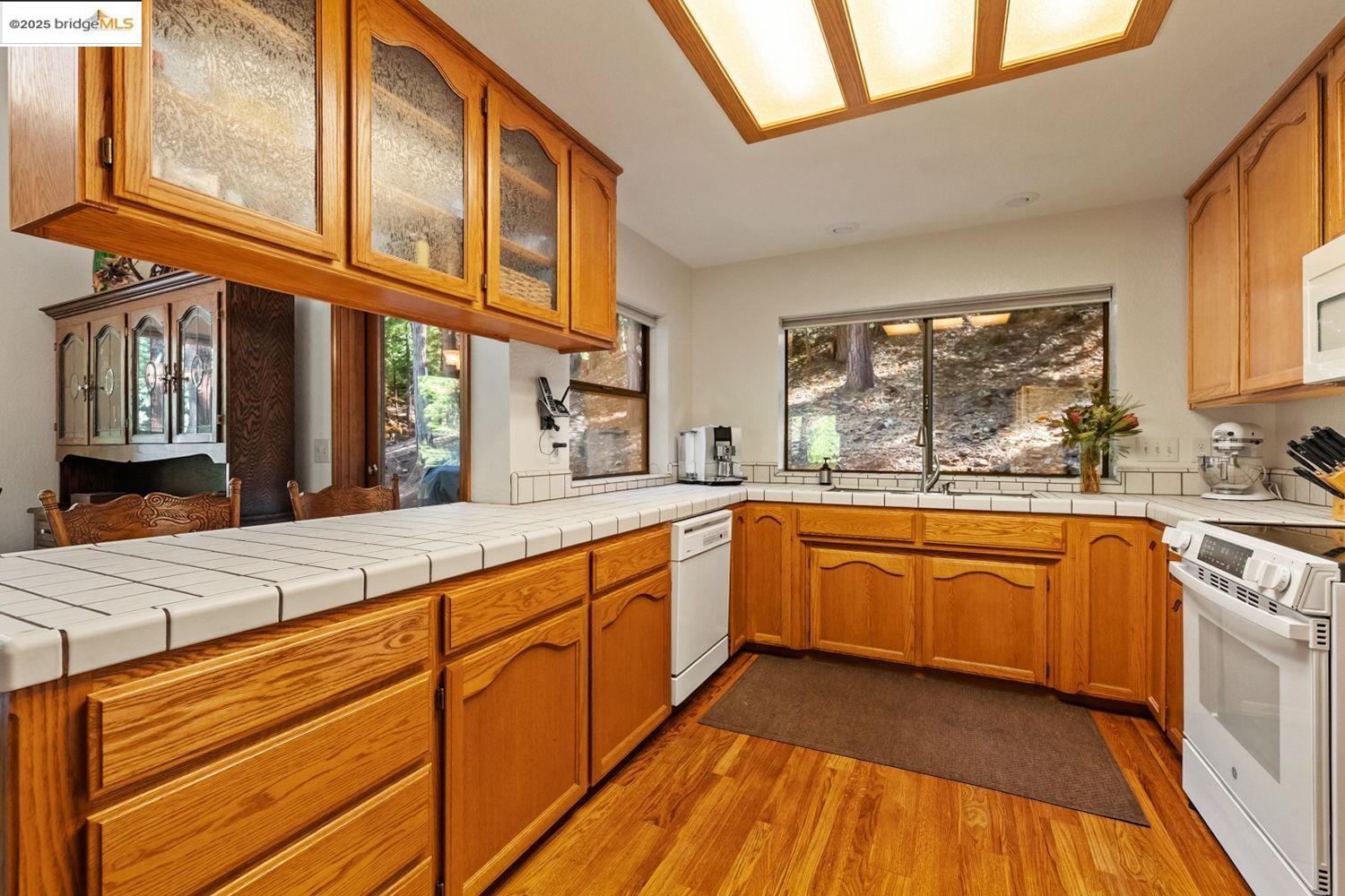 24181 Awahanee Road Sonora, CA 95370 - Photo 25 of 48 a large kitchen with stainless steel appliances granite countertop a sink and dishwasher a stove with wooden floor