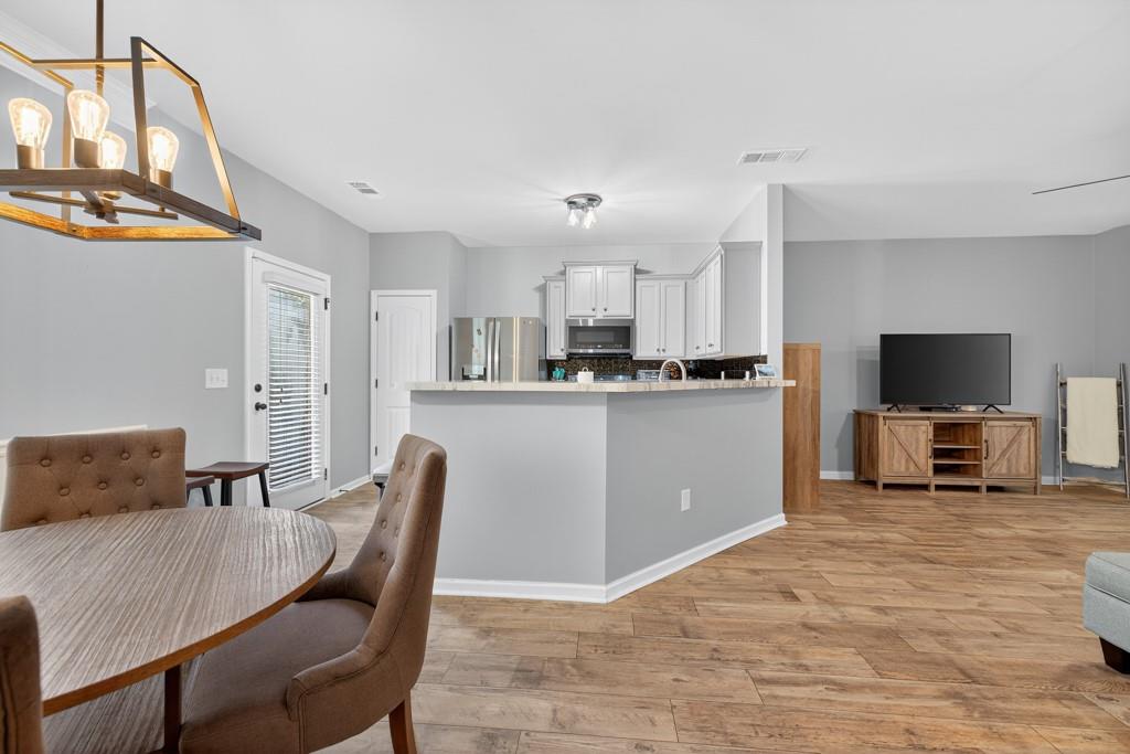 256 Valley Crossing Canton, GA 30114 - Photo 18 of 41 a kitchen with kitchen island a dining table chairs and a refrigerator