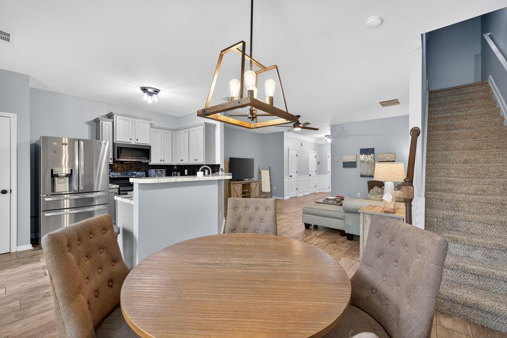 256 Valley Crossing Canton, GA 30114 - Photo 3 of 41 a kitchen with stainless steel appliances kitchen island granite countertop a refrigerator a stove a microwave oven a sink with island chairs and couches