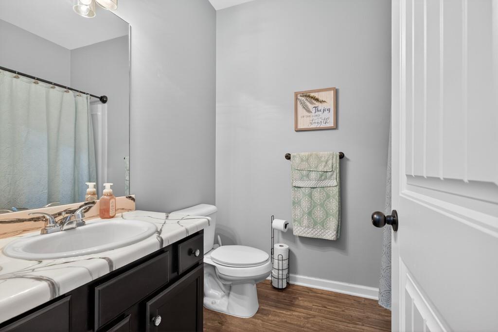 256 Valley Crossing Canton, GA 30114 - Photo 33 of 41 a bathroom with a granite countertop toilet a sink and a mirror