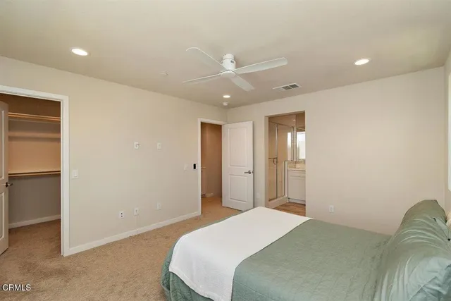 a bedroom with a bed and a ceiling fan