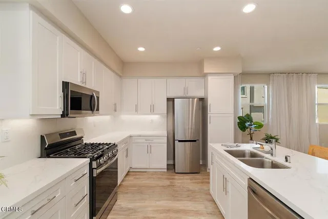 a kitchen with refrigerator a sink and a stove