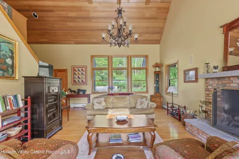 a living room with fireplace furniture and a large window