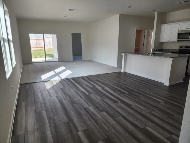 a view of a kitchen with wooden floor and a sink