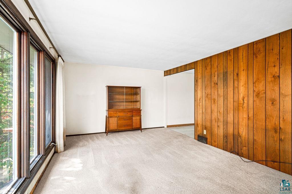 4930 Oneida Street Duluth, MN 55804 - Photo 5 of 19 Carpeted empty room featuring wood walls