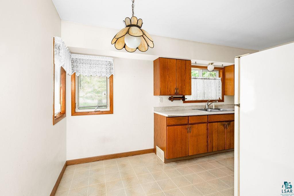 4930 Oneida Street Duluth, MN 55804 - Photo 6 of 19 Kitchen with white refrigerator, light tile patterned flooring, and sink
